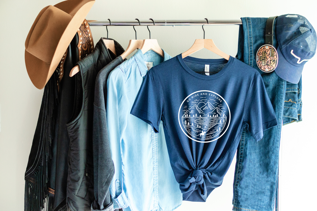 navy blue  short sleeve tshirt printed with a mountain scene and a silhouette horse and rider with the saying Go Ride and Explore arched across the top.