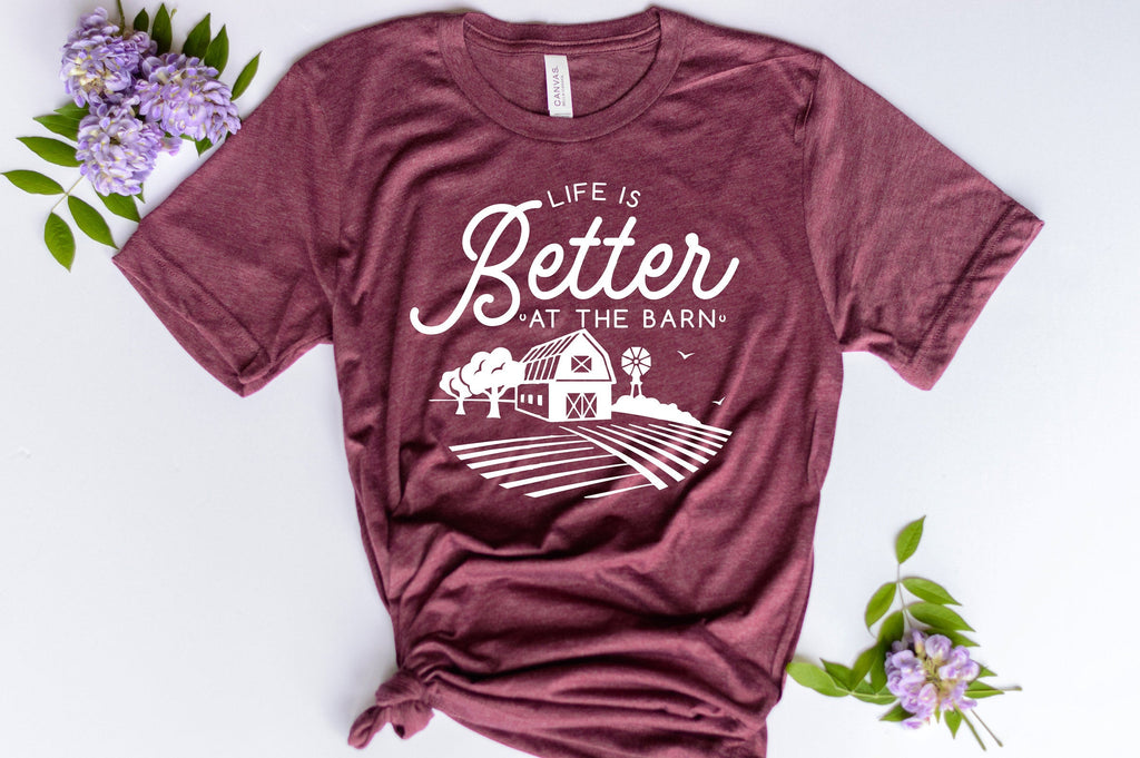 maroon short sleeve graphic tshirt that reads life is better at the barn with a barn scene.